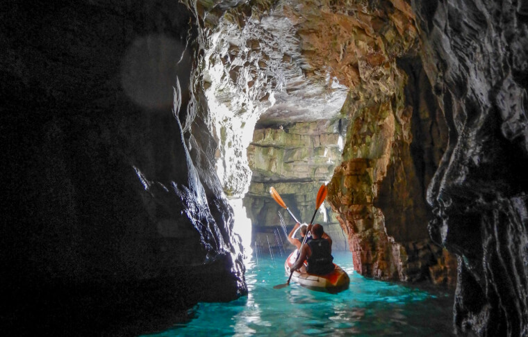 kayak passing through cave