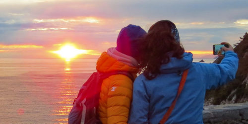 Couple taking photo at sunset.