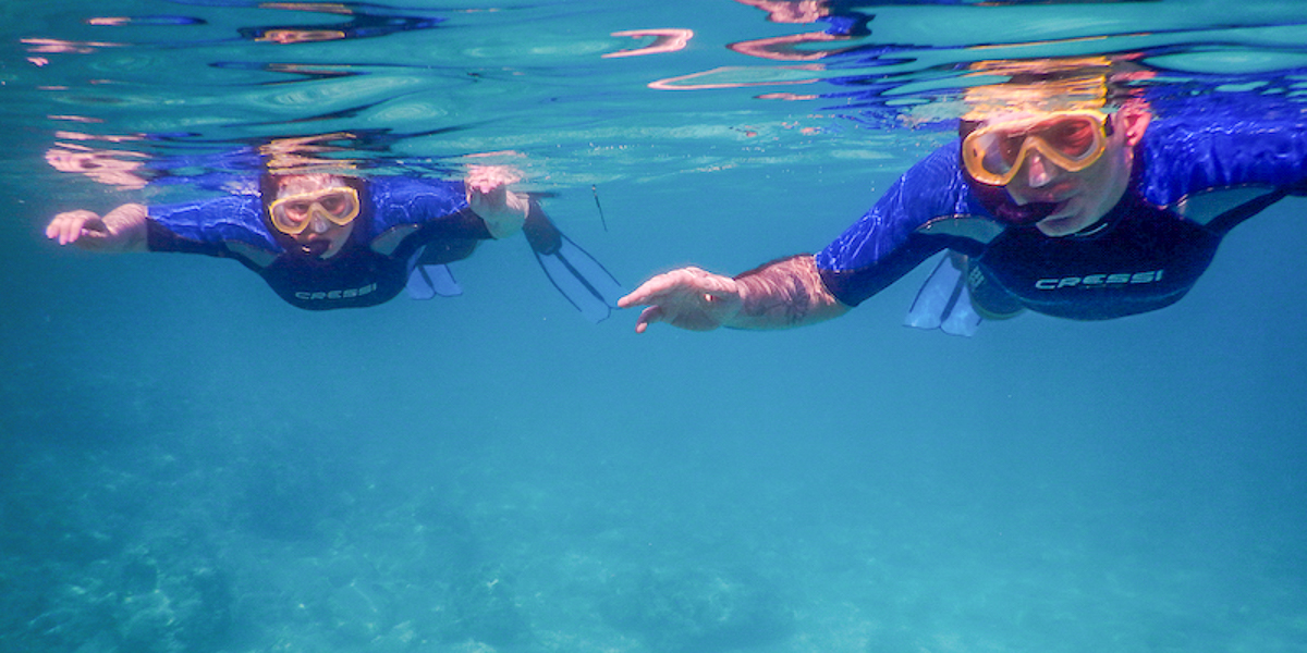 Couple snorkeling in a crystal clear sea.