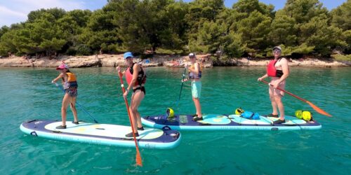 Family paddle-boarding on a tandem sup boards in Pula, Croatia.